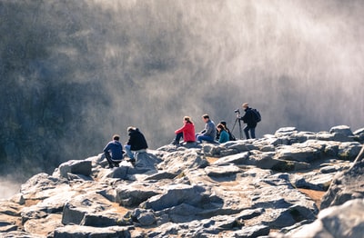 一群人坐在灰色的岩石上
